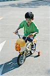 Boy riding bicycle with training wheels