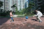 Father and son playing ball in apartment complex