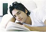 Homme couché dans son lit, lecture