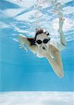 Adolescente à la piscine, tenir tête et portant des lunettes, vue sous l'eau