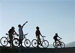 Mountain bikers standing with bikes, looking up