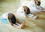 Yoga class, women doing seated forward bend