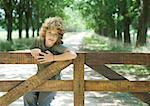 Boy hanging on fence