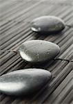 Smooth black stones on bamboo mat