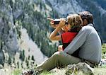 Spain, Catalonia, father and daughter looking at view, girl using binoculars