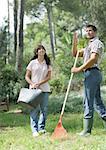 Man and teenage girl doing yard work