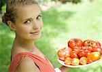 Woman holding bowl full of tomatoes