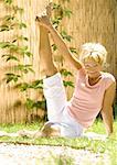 Senior woman doing leg stretch outdoors