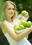 Woman holding bowl of apples, smiling at camera