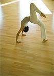 Yoga class, woman doing one-legged bridge pose