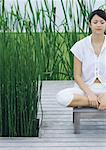 Woman sitting on deck, meditating