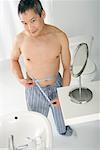 Man Measuring Stomach in Bathroom