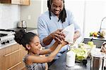 Father and Daughter Making Applesauce in Kitchen