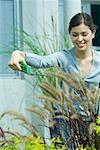 Young woman pruning outdoor plants