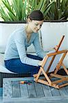 Junge Frau sitzend mit Staffelei, zeichnen mit Pastellkreide
