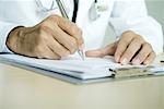 Doctor writing prescription, close-up of hands