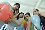 Teenage friends holding balloons