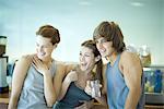 Young adults in exercise clothing, taking break in health club cafeteria