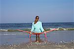 Woman sitting on a beach chair while looking at the sea