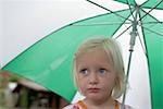 Little blond girl under an umbrella