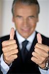 Senior businessman showing thumbs up