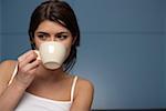 Young woman drinking from a cup, portrait