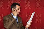Businessman holding documents while phoning with a mobile phone