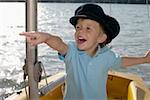 Little boy in a plastic boat is pointing at something, close-up
