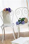 Chairs with hydrangea and shopping bags filled with flowers