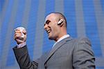 Businessman with headset crushing a beaker