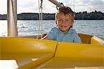 Petit garçon conduire un bateau en plastique
