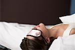 Young woman with a sleep mask in bed, close-up