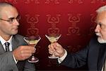 Two businessmen clinking glasses with martini