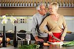 Blond woman and gray-haired man cooking together
