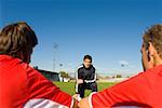 Two soccer players listening to the coach