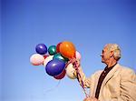 Man Holding Bunch of Balloons