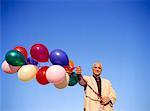 Man Holding Bunch of Balloons