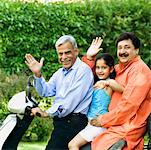 Alter Mann mit seinem Sohn und Enkelin einen Motorroller fahren
