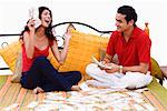 Young couple sitting on the bed and sharing paper currency