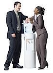 Businessman and a businesswoman standing beside a water cooler
