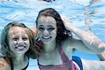 Girls swimming underwater in pool