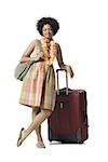 Portrait of a young woman standing with luggage