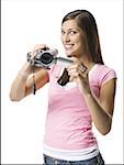 Portrait of a young woman holding a home video camera
