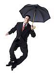 Portrait of a businessman holding an umbrella and jumping