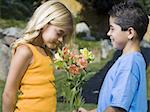 Profile of a boy giving flowers to a girl