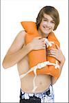 Boy in swim trunks with life vest