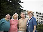 Portrait of two senior couples smiling together with their arms around each other