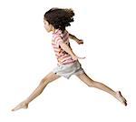 Portrait d'une jeune fille sautant avec ses bras tendus