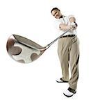 Mid adult man swinging a golf club