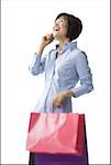 Mid adult woman holding shopping bags and talking on a cell phone